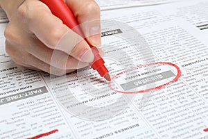 Woman marking advertisement in newspaper. Job search concept