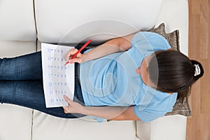 Woman Marking Date On Calendar