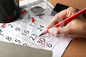 Woman marking date in calendar, closeup. Deadline concept