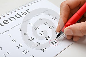 Woman marking date in calendar, closeup. New Year countdown