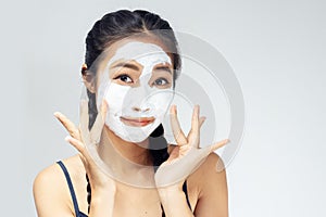 A woman is marking a face with mud