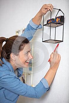 woman marking wall with pencil