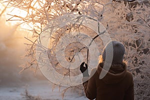 Woman marveling at intricate frost patterns on winter morning. Generative AI