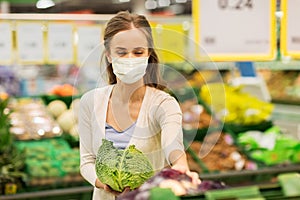 Woman in mask buying savoy at grocery store