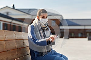 Woman in mask cleaning hands with antiseptic wipe