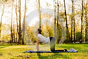 Woman with mask meditating/practicing yoga in nature alone.Social distancing and active healthy lifestyle. Mindfulness meditation.