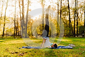 Woman with mask meditating/practicing yoga in nature alone.Social distancing and active healthy lifestyle. Mindfulness meditation.