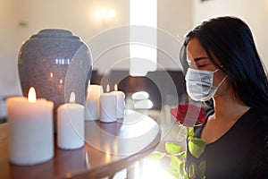 Woman in mask with rose at funeral in church