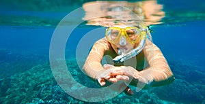 Woman with mask snorkeling in clear tropical water