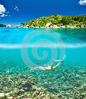 Woman with mask snorkeling in clear water