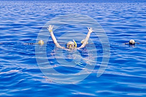 Woman with mask snorkeling in clear water wiving photo