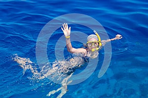 Woman with mask snorkeling in clear water photo