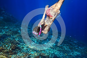 Woman with mask swimming underwater in tropical sea