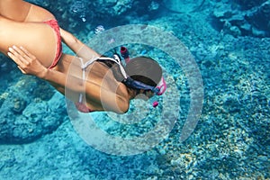 Woman with mask swimming underwater in tropical sea