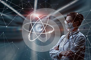 A woman in a mask in uniform looks at an atom on a blurred background