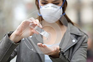 Woman with mask using hand sanitizer preventing contagion photo