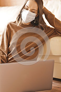 Woman in mask working at notebook