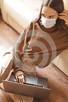 Woman in mask working at notebook