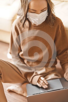 Woman in mask working at notebook