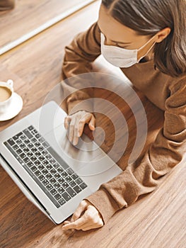 Woman in mask working at notebook