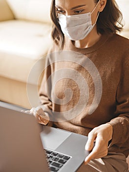 Woman in mask working at notebook