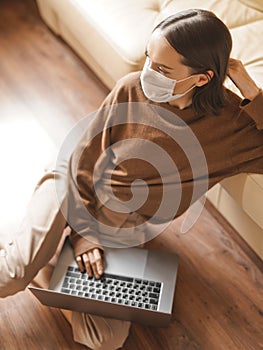 Woman in mask working at notebook