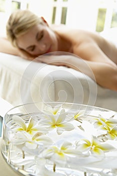 Woman On Massage Table With Flowers In Foreground photo