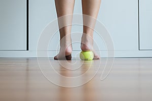 Woman massage with tennis ball to her foot in bedroom,Feet soles massage for plantar fasciitis