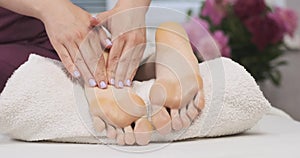 Woman massage therapist doing foot massage in spa salon. Relaxing massage in wellness center.