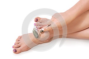 Woman massages her feet with a stone massager. natural cosmetics, spa, pedicure, skin care concept. copyspace
