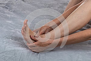 A woman is massaging her feet. Revitalizing foot massage. Women& x27;s feet health care. Spa treatments at home. Close-up