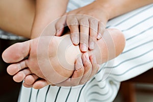 Woman massaging her painful barefoot, healthcare and medical concept