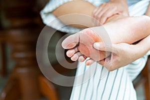 Woman massaging her painful barefoot, healthcare and medical concept