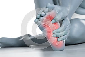 Woman massaging her painful foot on white background