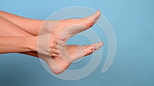 Woman massaging her tired feet. Leg health and body care concept. Cropped view.