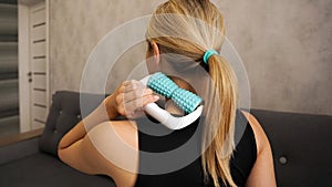 Woman massaging herself with body roller. Neck massage. Prevention of neck pain