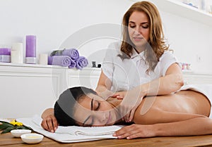 Woman massagist make body massage in spa wellness center photo