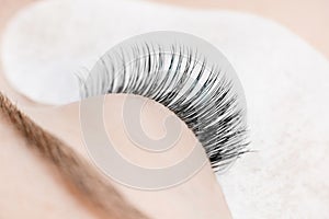 Woman master making fake long lash Eyelash extension procedure
