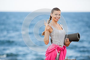 Woman with Mat for fitness on the coast