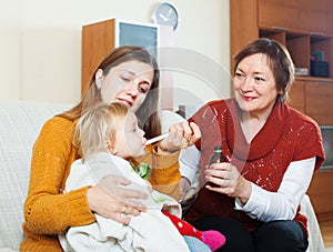 Woman with mature mother caring for sick baby
