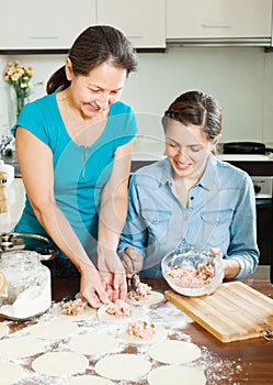 Woman with mature mother making dumplings