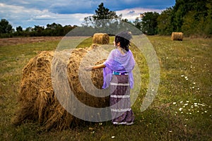 Woman on a meadow with hay bale