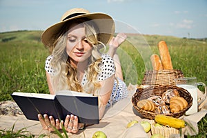 Woman in a meadow reads a book. picnic, countryside. milk and bakery products