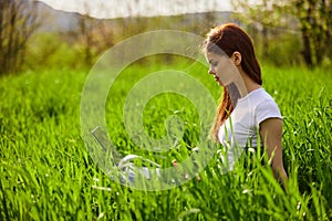 woman on the meadow relaxing and using a laptop