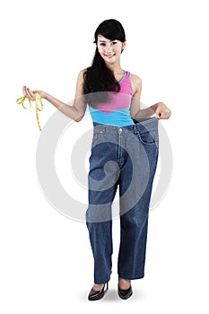 Woman with measurement tape and old jeans