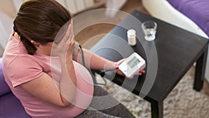 A woman measures blood pressure with an electronic pressure gauge, headache during pregnancy, poor health.selective focus on the