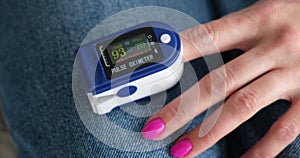 Woman Measures Pulse and Oxygen Saturation with a Pulse Oximeter