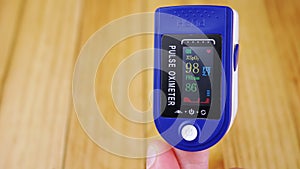 Woman Measures Pulse and Oxygen Saturation Using a Pulse Oximeter at Home