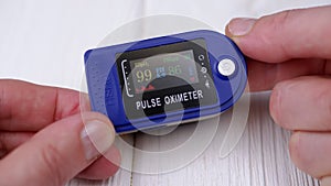 Woman Measures Pulse and Oxygen Saturation Using a Pulse Oximeter at Home