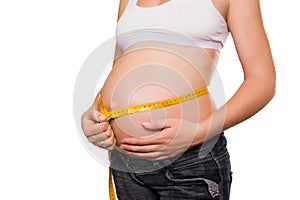 Woman measures a stomach by tape